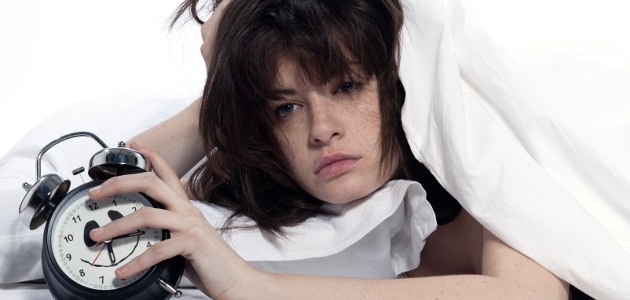 fille dans un lit qui tient un r�veil